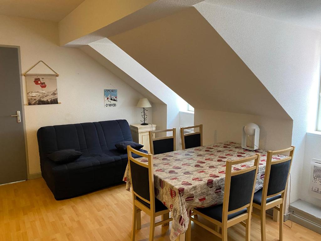 un salon avec une table et un canapé bleu dans l'établissement Le petit montagnard, à Cauterets