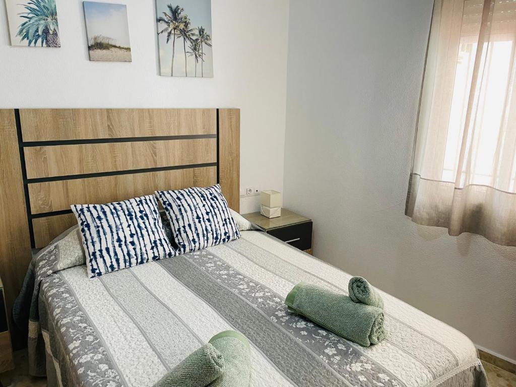 een slaapkamer met een bed met twee handdoeken erop bij Apartamento Conil Playa & Centro, perfecto descanso, con Aire Acond y WIFI in Conil de la Frontera