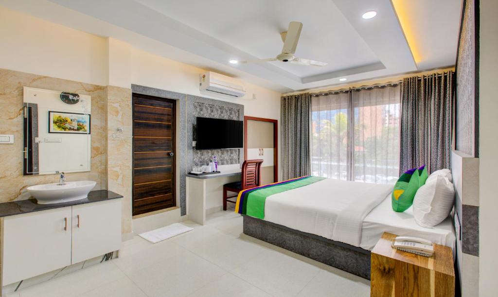 a hotel room with a bed and a sink at Treebo Trend Love Shore Residency Near Lakeshore Hospital in Cochin