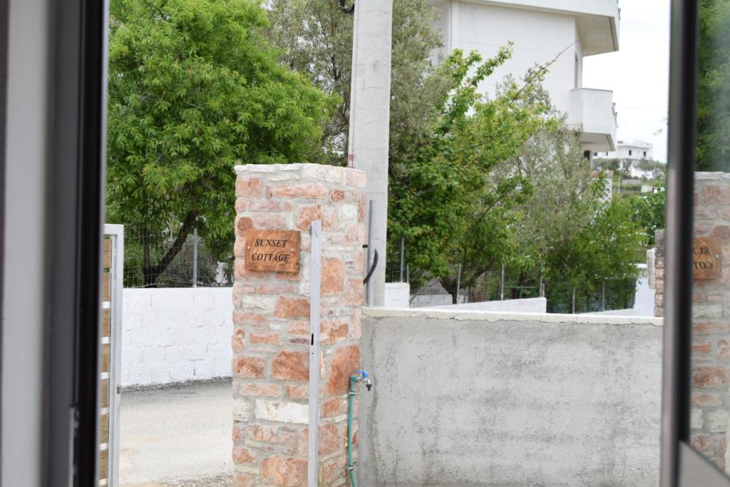 卡萨米尔Sunset Cottage 2的墙上有标志的砖墙门