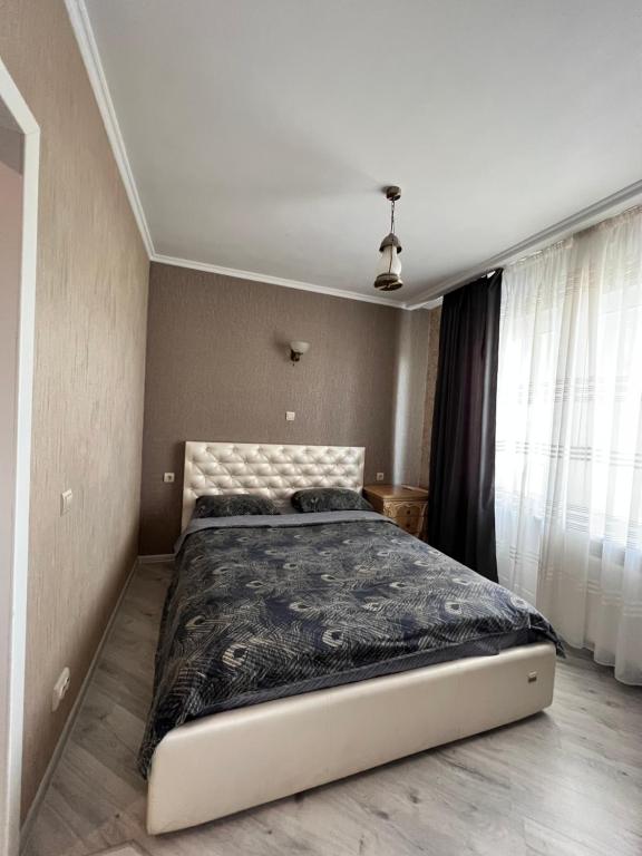 een slaapkamer met een groot bed en een zwart dekbed bij Видовая 1 ком на Осокорках in Kiev