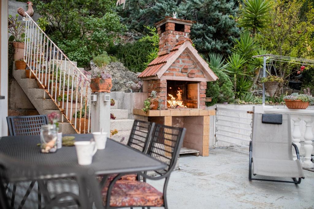 a patio with a table and a pizza oven at Apartments Kos in Supetarska Draga