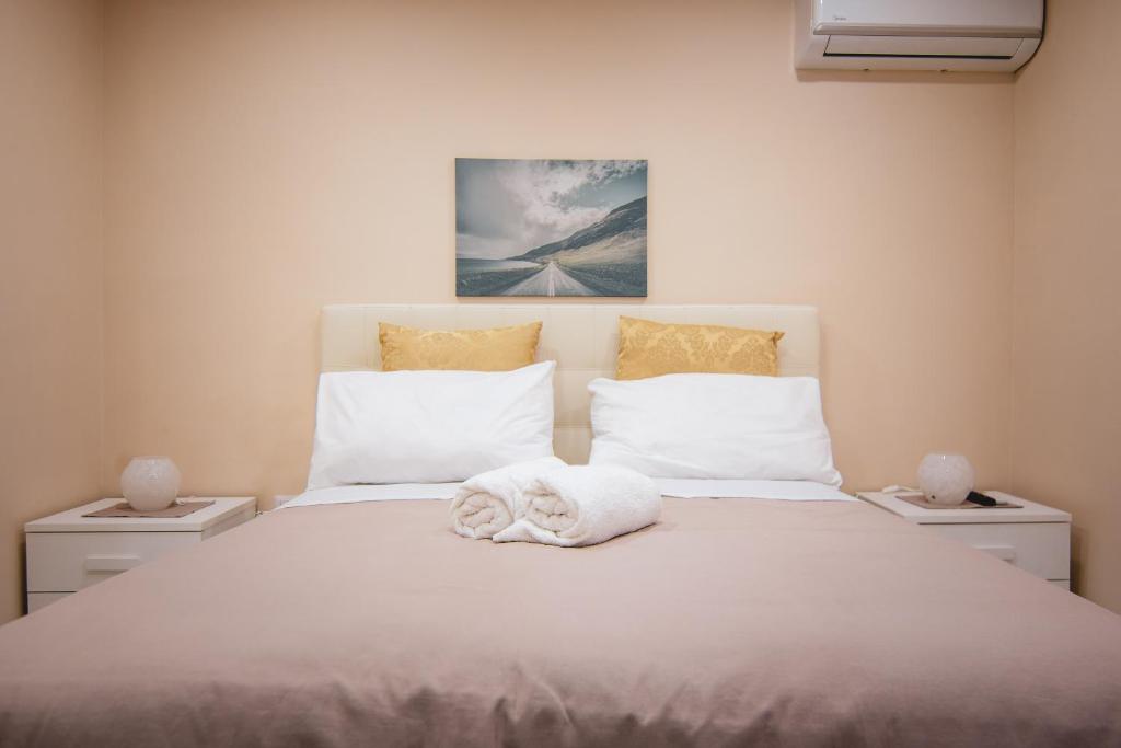 a bedroom with a white bed with towels on it at Historical Center Porto Suite in Naples
