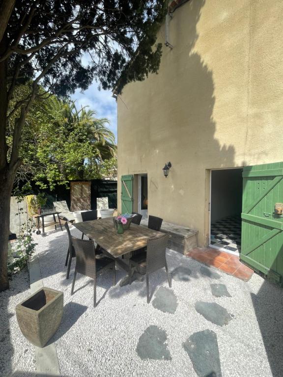 a patio with a wooden table and chairs at Appartement plein centre avec jardin in Saint-Tropez