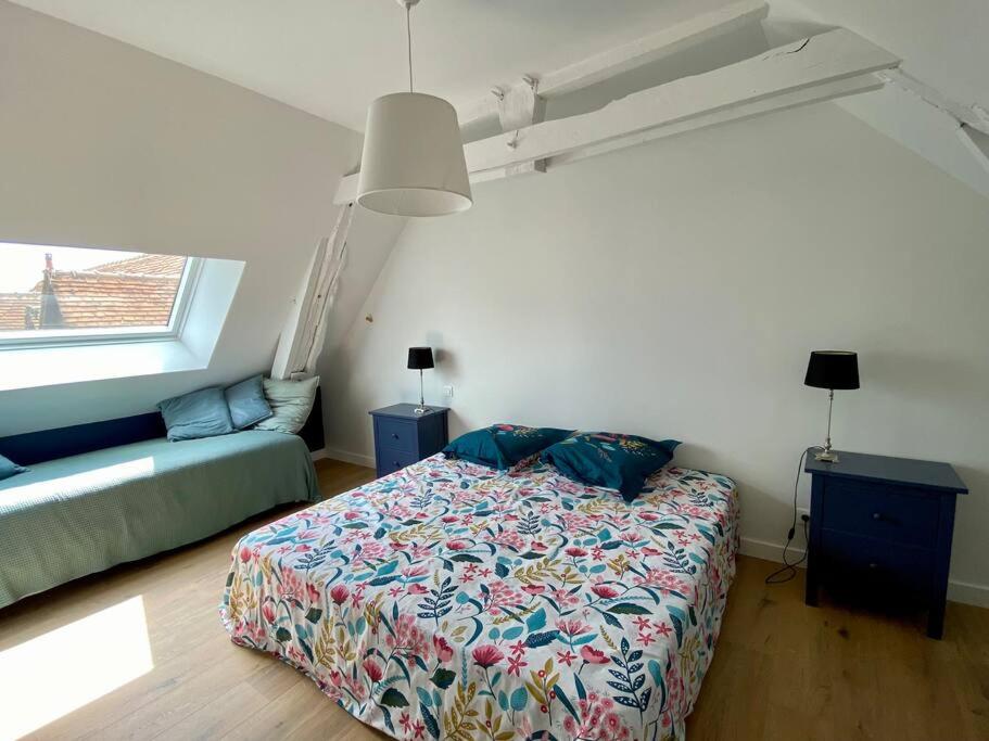 a bedroom with a bed and a couch and a window at Maison avec piscine au calme 