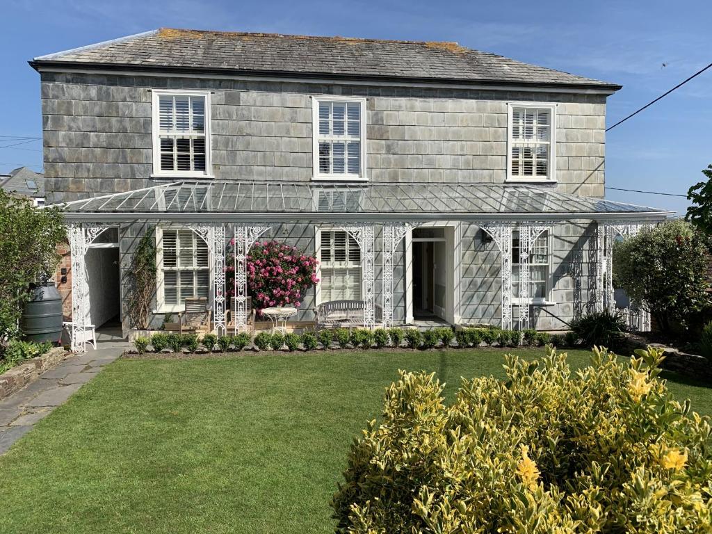 an old house with white windows and a yard at Coswarth House in Padstow