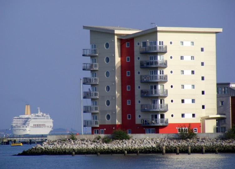 ein großes Apartmenthaus neben einem Kreuzfahrtschiff in der Unterkunft The Lantern Building in Southampton