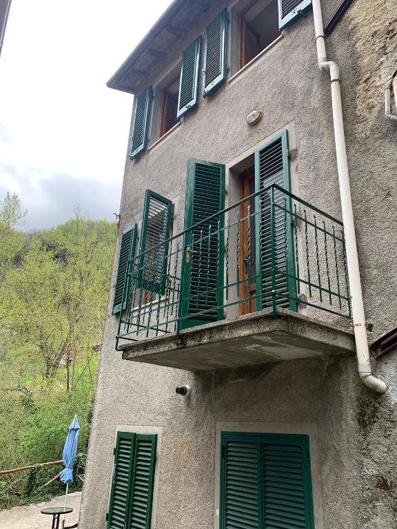 ein Gebäude mit grünen Rollläden und einem Balkon in der Unterkunft Casa Piglione in Pian dʼOrsina