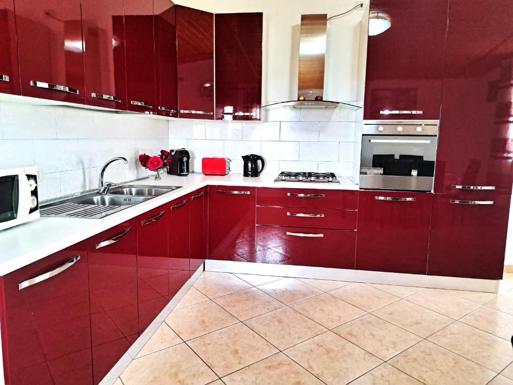 a kitchen with red cabinets and a sink at Da Delfo in Agnone Bagni