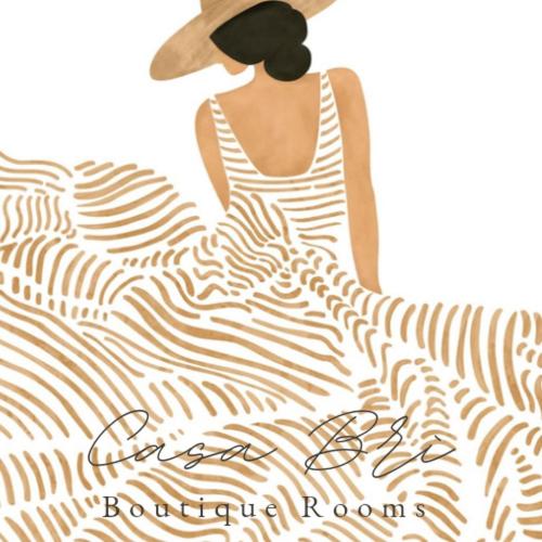 a woman in a striped dress and a hat at Casa Brì Boutique Rooms in Santa Teresa Gallura
