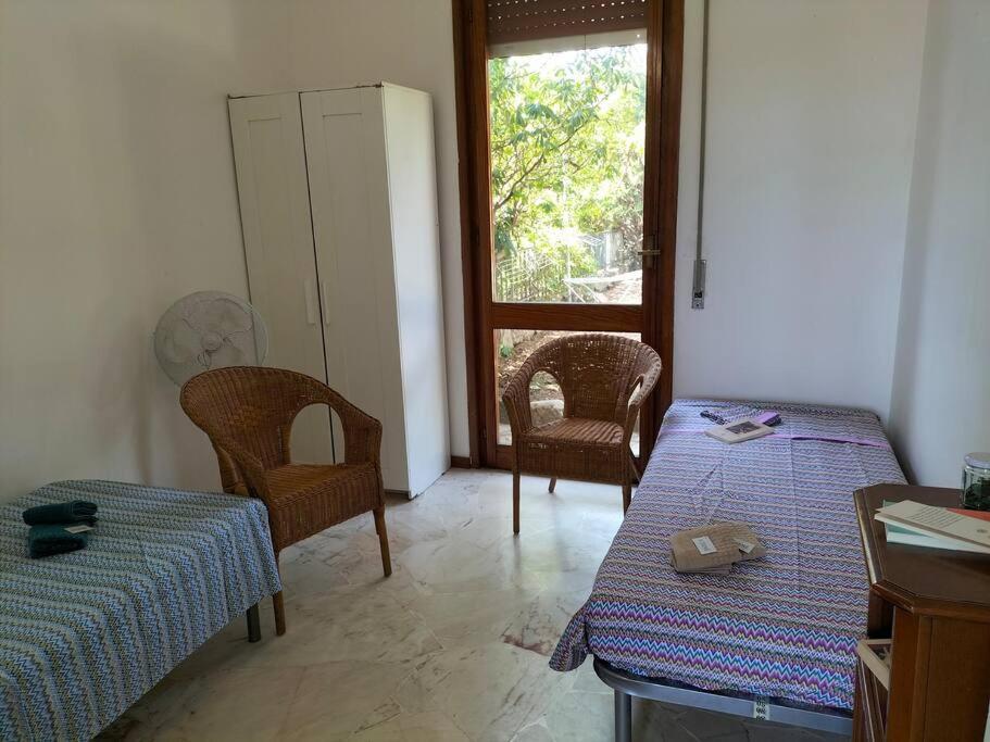 a room with two beds and chairs and a window at Casa con giardino: Varazze in Varazze