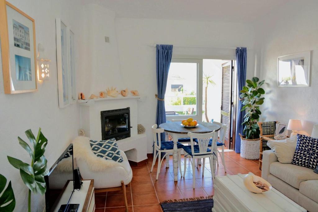 ein Wohnzimmer mit einem Sofa und einem Tisch mit Stühlen in der Unterkunft Casa Blu, Beach Boho Chic, Beach and Pool - Fast Wifi in Porches