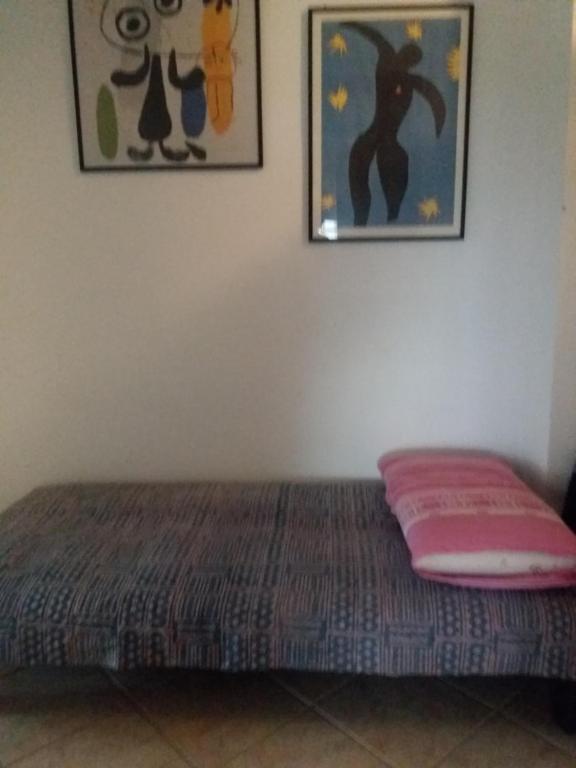 1 cama en una habitación con 2 cuadros en la pared en Stanza in appartamento, en Latina
