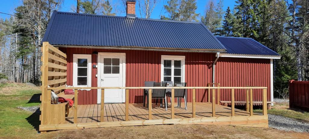 un bâtiment rouge avec une terrasse et une maison dans l'établissement Rosa's stuga, 