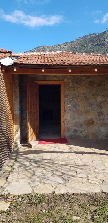 une porte menant à un bâtiment avec un tapis rouge dans l'établissement Olympos stone villa 2, à Kumluca