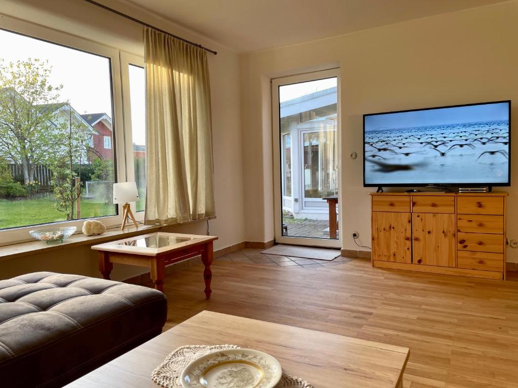 a living room with a large flat screen tv at Ferienhaus Anna in Dagebüll