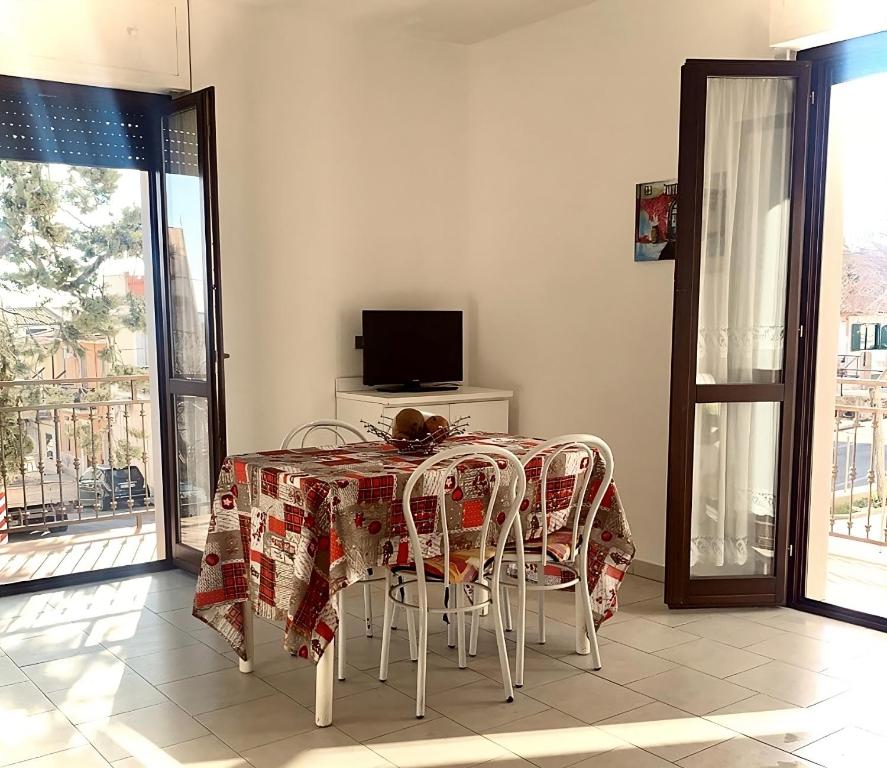 une salle à manger avec une table, des chaises et une télévision dans l'établissement "La Casa di FRILA" Bilocali a Borgo Celano, à San Giovanni Rotondo