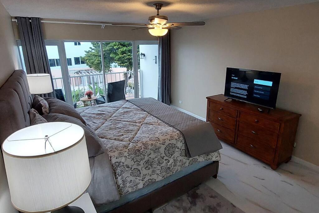 a bedroom with a bed and a flat screen tv at Nassau Harbour Cozy 2 bedroom Condo in Nassau