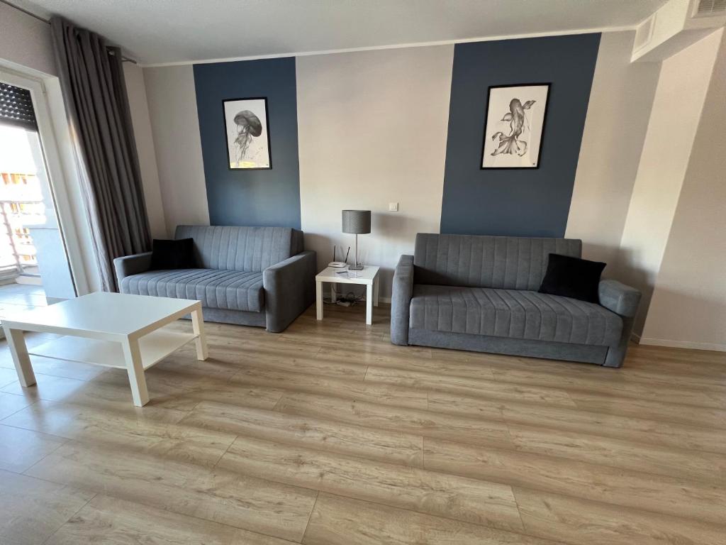 a living room with two couches and a table at Apartament Silver in Pogorzelica