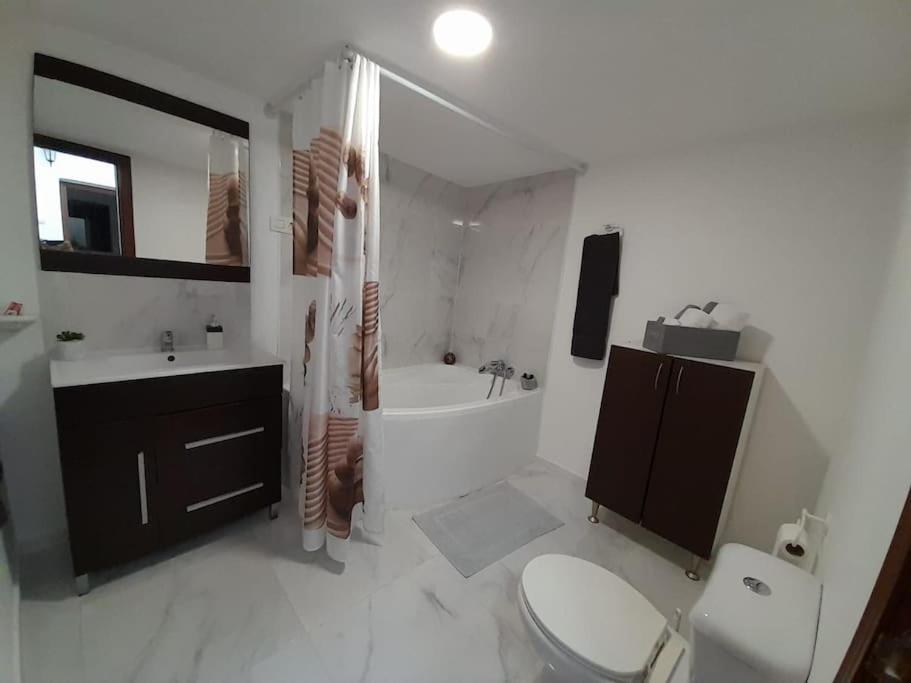 a bathroom with a toilet and a sink and a tub at Anfitrión particular in Castellón de la Plana