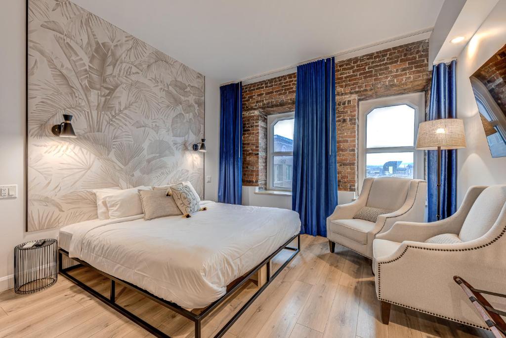 1 dormitorio con 1 cama y 2 sillas en Hébergement touristique ▐ 335 Saint Joseph E▐, en Quebec