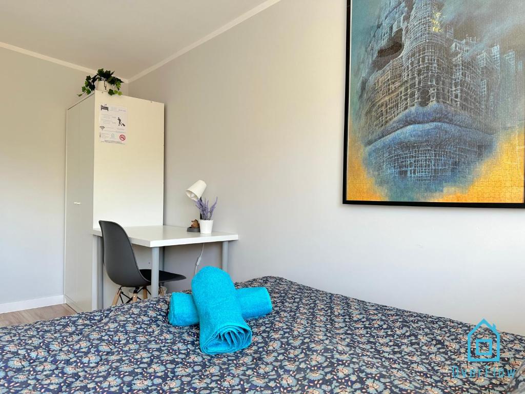 Un dormitorio con una cama con almohadas azules. en Beksiński Room en Gdansk