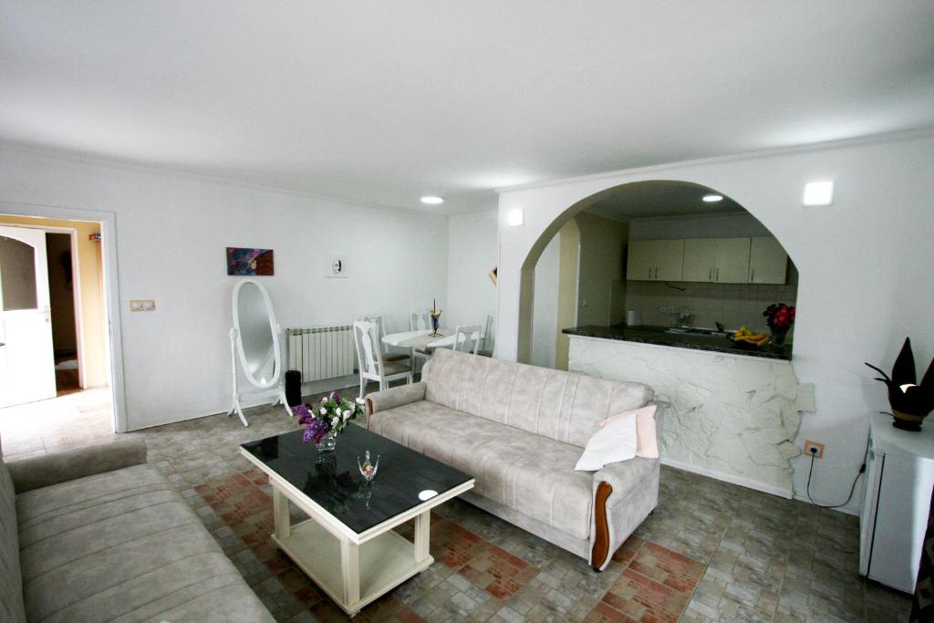 een woonkamer met een bank en een tafel bij Apartment Forest Lipovica in Belgrado
