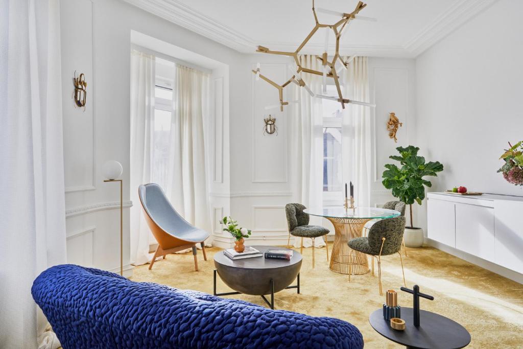 a living room with a blue couch and chairs at Halcyon Days Luxembourg in Luxembourg