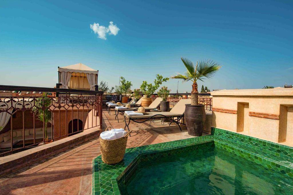 uma varanda com uma piscina no topo de um edifício em Riad Livia Marrakech - Adults Only em Marrakech