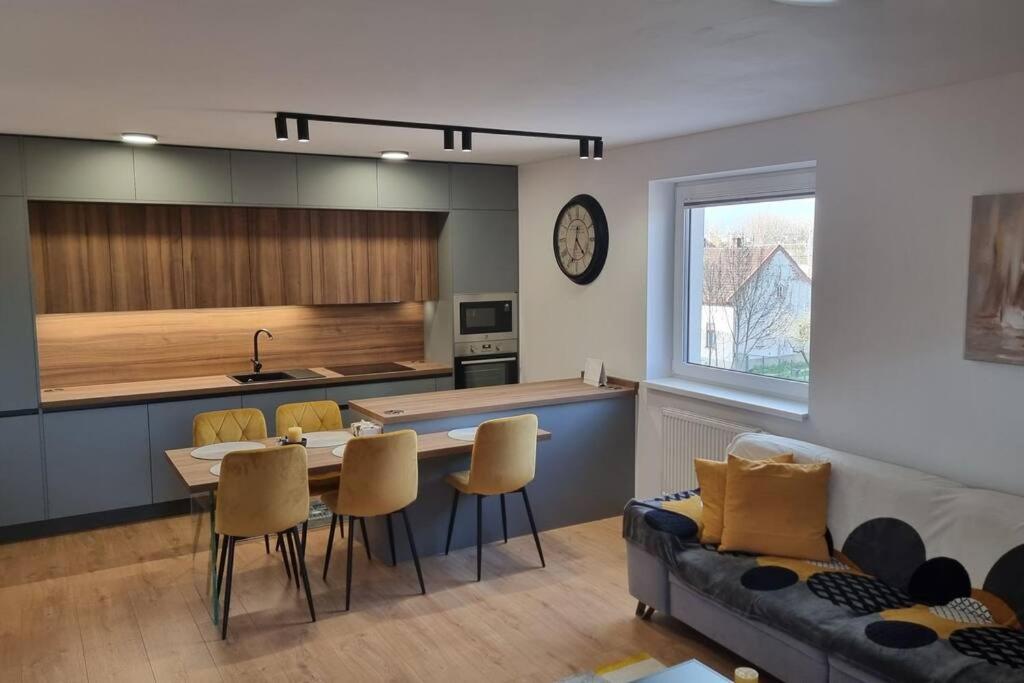 a kitchen and living room with a table and chairs at komfortná novostavba v centre in Poprad