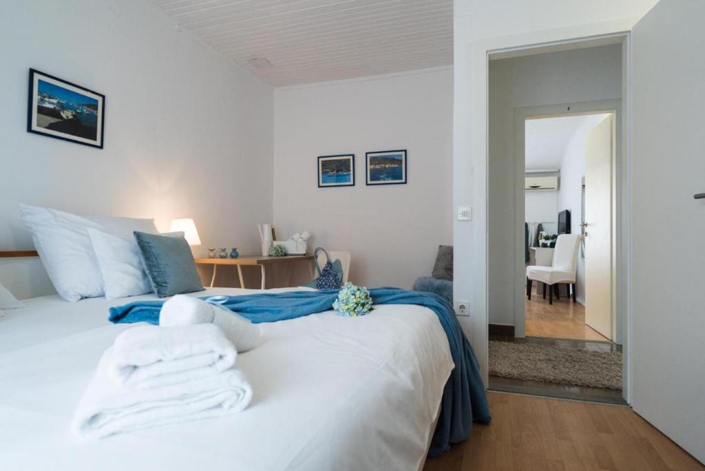 - une chambre dotée d'un grand lit blanc avec des draps bleus dans l'établissement GUEST HOUSE LANA 1, à Split