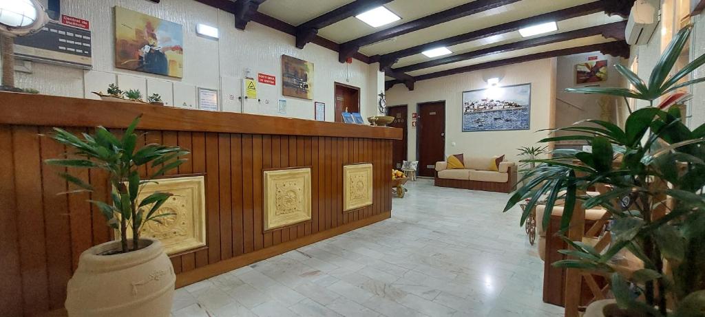 a lobby with a waiting room with potted plants at Apartamentos Turisticos Praia Grande in Ferragudo