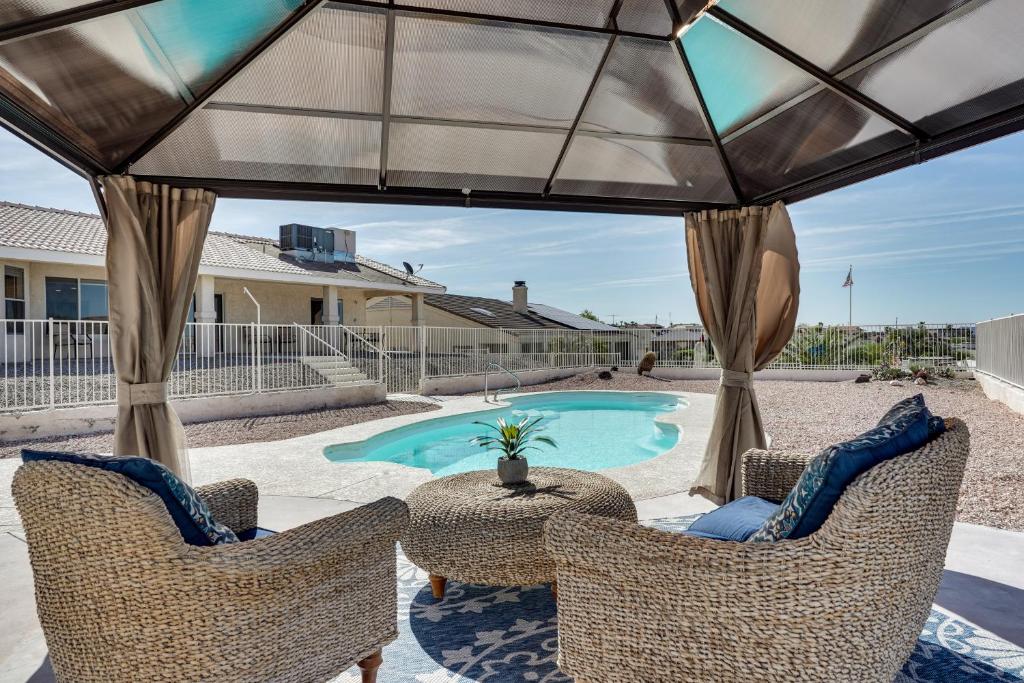 哈瓦蘇湖城的住宿－Lake Havasu City Home with Private Pool and Gazebo!，一个带藤椅的庭院和一个游泳池