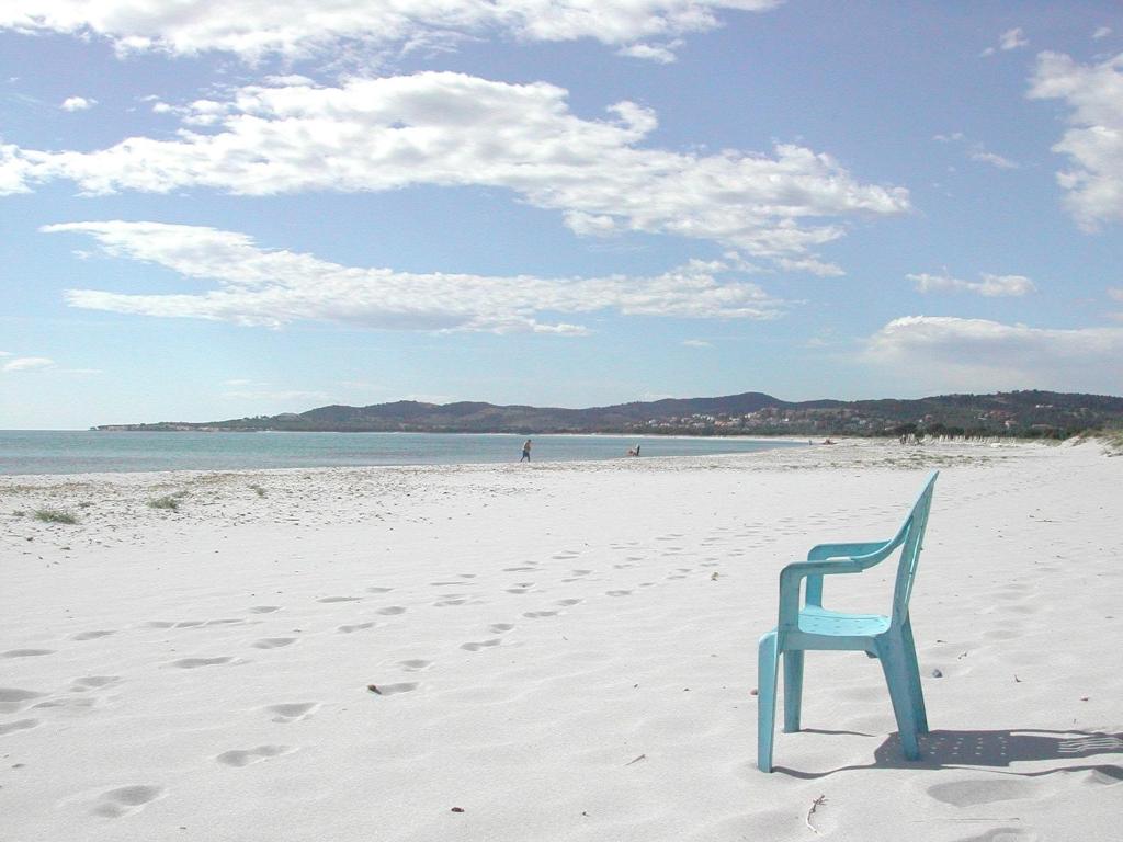 uma cadeira azul sentada na areia numa praia em La casa di Tonia em La Caletta
