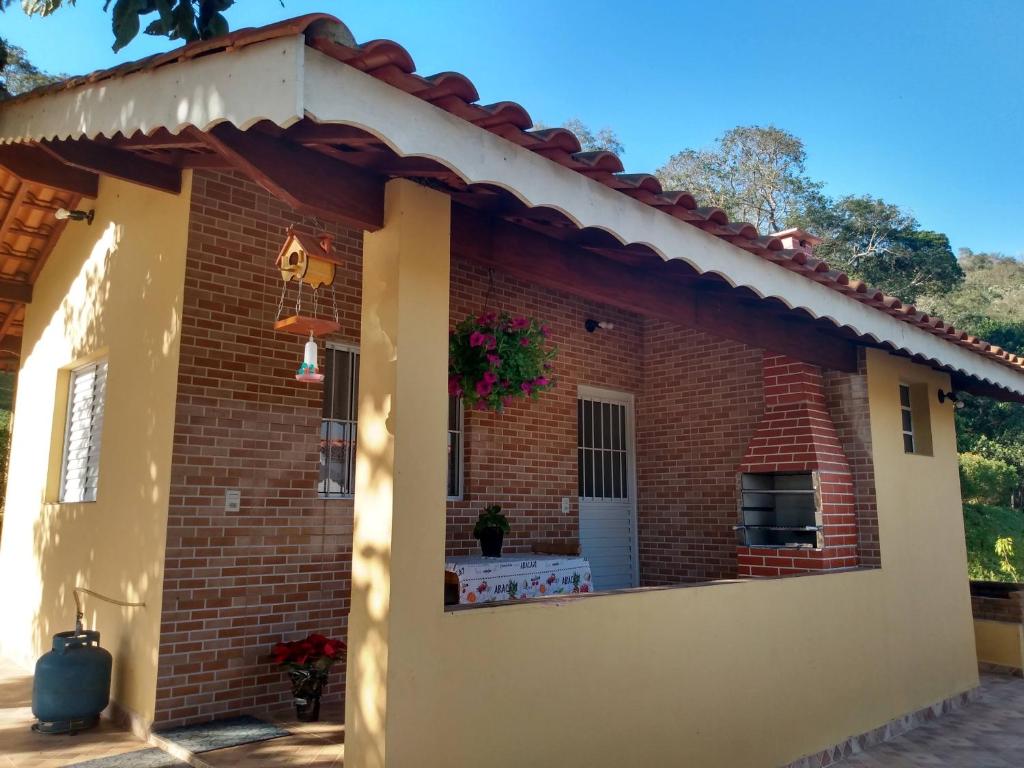 a brick house with a large window at Pousada Sitio Pauletto Chales e Casas com cozinha in Jarinu