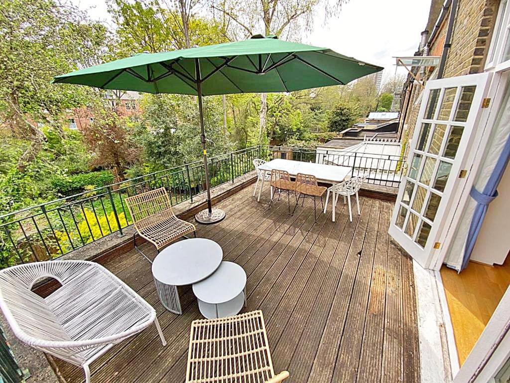a patio with a table and chairs and an umbrella at Amazing holidays home with a terrace in London