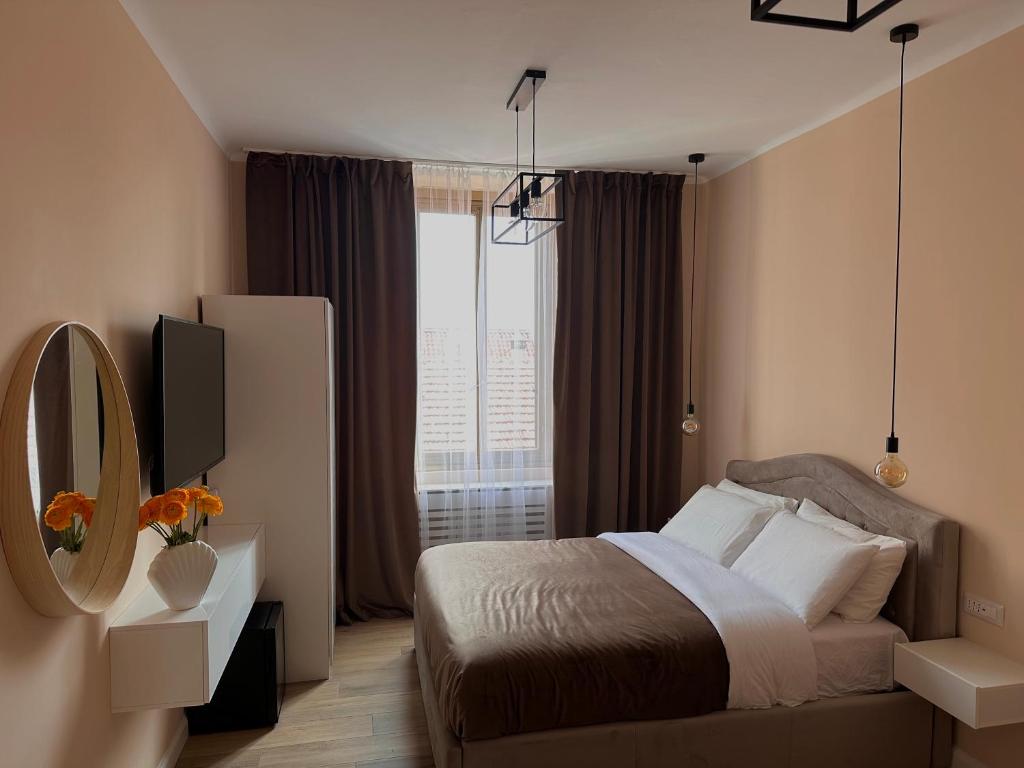 1 dormitorio con cama, espejo y ventana en Rhospitality - Visconti Affittacamere, en Rho
