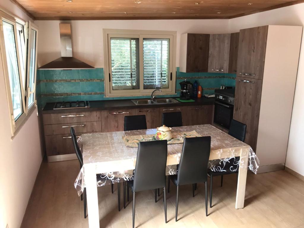 cocina con mesa con sillas y fregadero en Villa Lory, en Terrasini