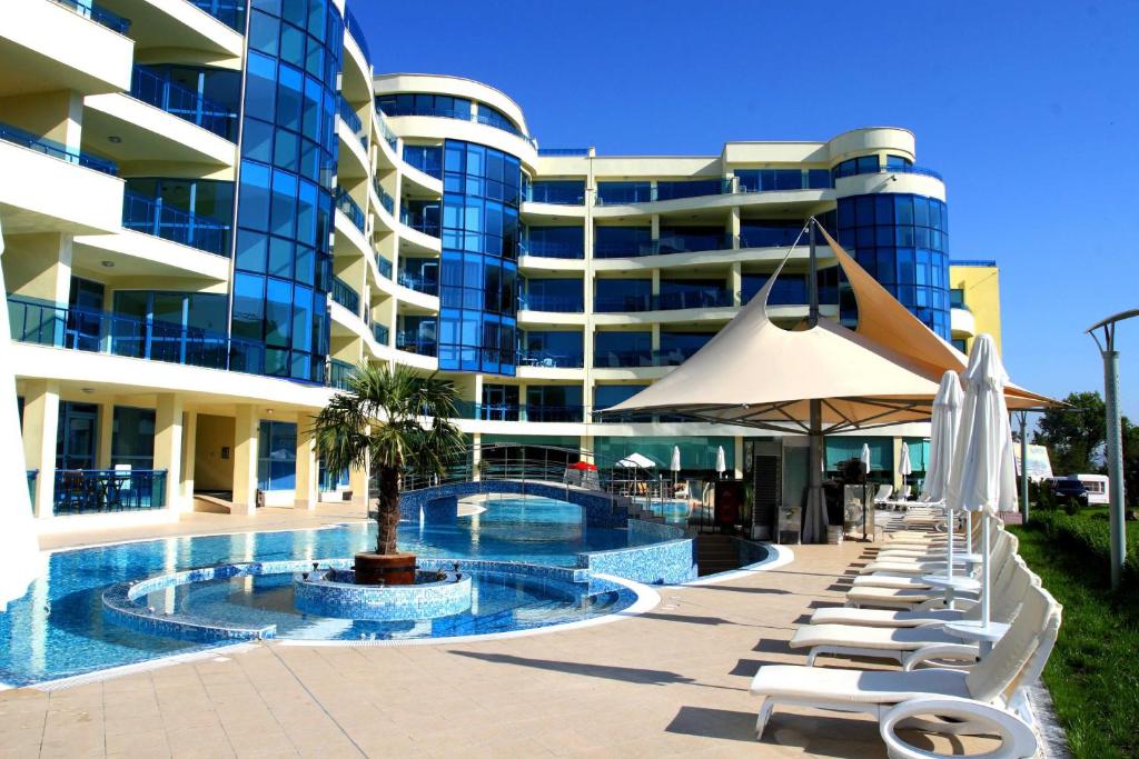 un hotel con piscina, sillas y un edificio en Aparthotel Marina Holiday Club & SPA - All Inclusive & Free Parking, en Pomorie