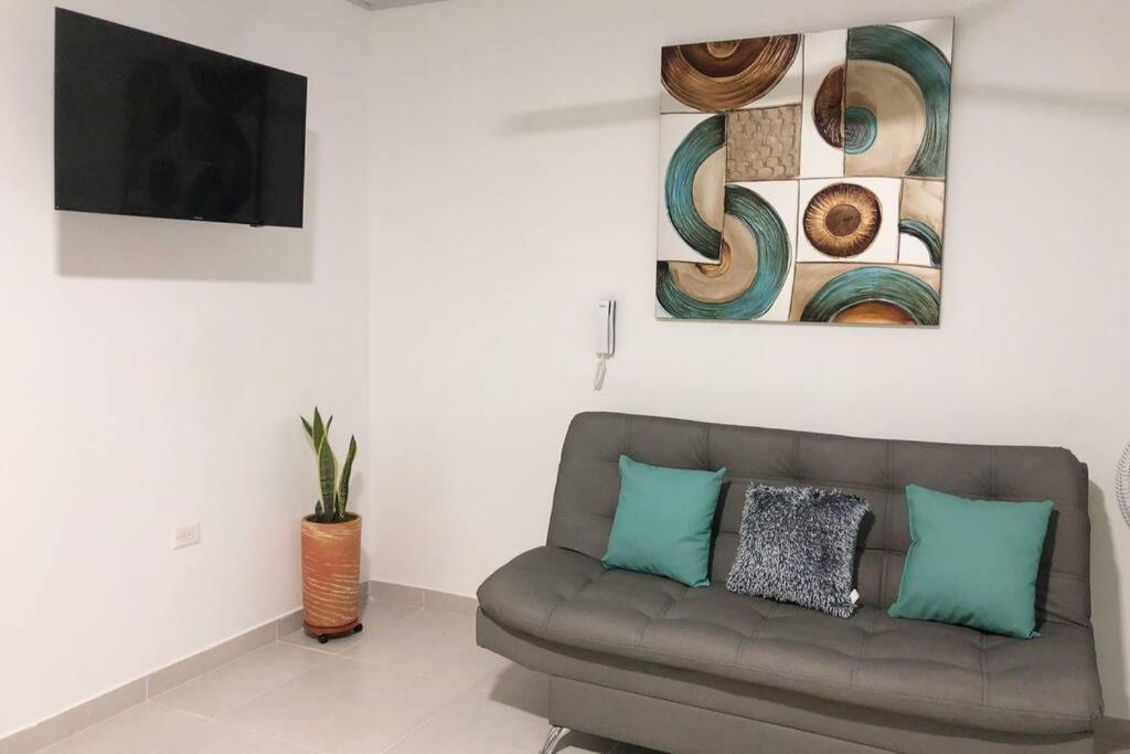 a living room with a couch and a tv at Hermoso apartamento en Doradal Antioquia in Doradal