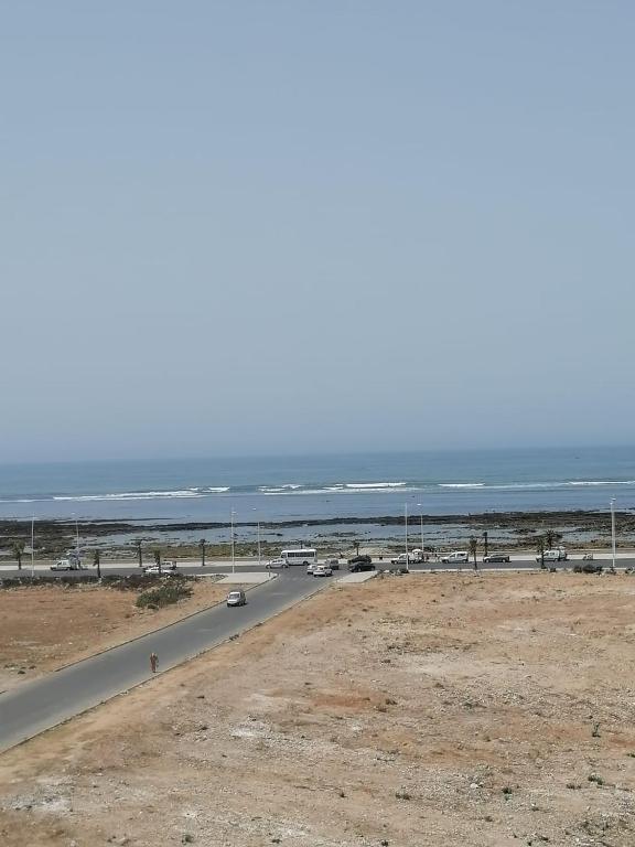 una strada vicino all'oceano con le auto sopra di Appartement Sidi Bouzid a El Jadida