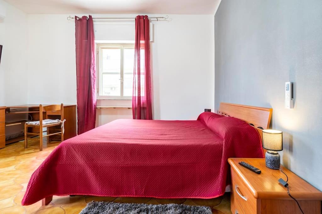 una camera con letto rosso e finestra di casa Gabriella a SantʼEufemia Lamezia