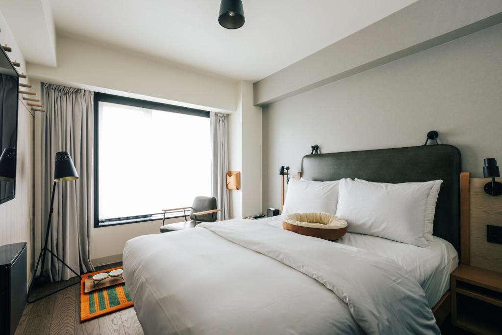 Postel nebo postele na pokoji v ubytování Moxy Osaka Umeda