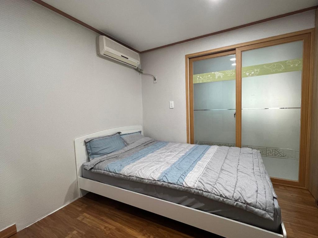 a small bedroom with a bed and a window at Sangmin Sweet in Daejeon
