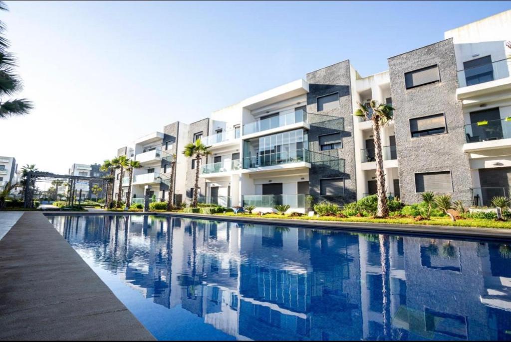een appartementencomplex met een zwembad ervoor bij Perla Garden Bay in Casablanca