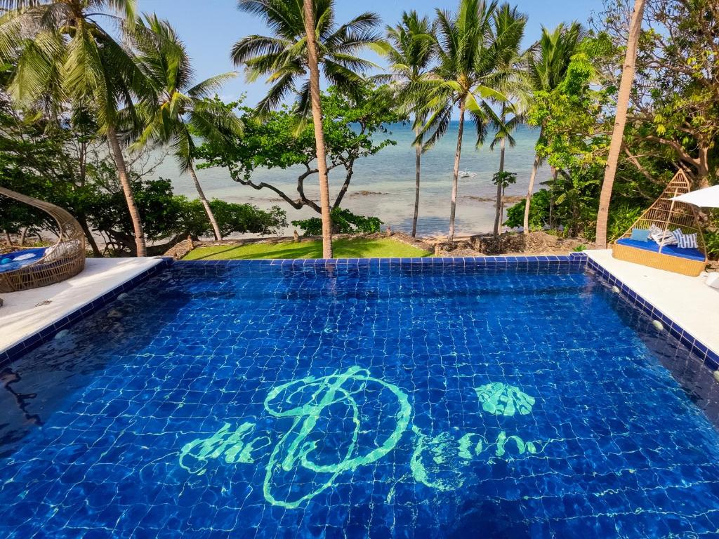 a swimming pool with the ocean in the background at The Dream Beach Resort in Taytay