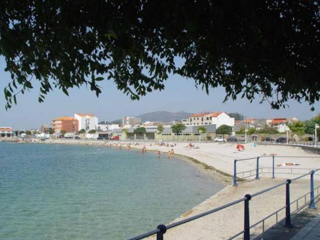 a beach with a bunch of people laying on the sand at Vivienda a pie de playa in Vilagarcia de Arousa