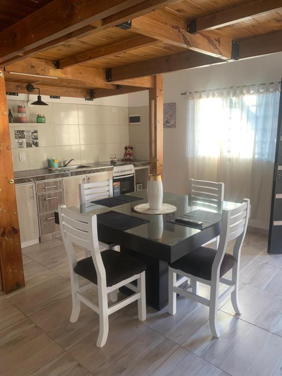 a kitchen with a black table and white chairs at AQUI ES 2 !!! in Banfield