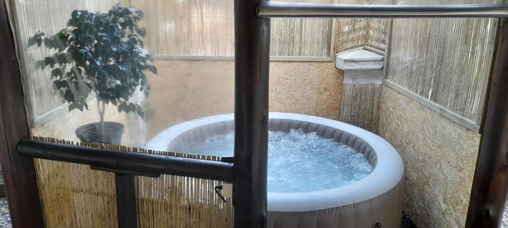 El Miyagi في بيريابوليس: حوض استحمام ساخن في نافذة يوجد فيها نبات