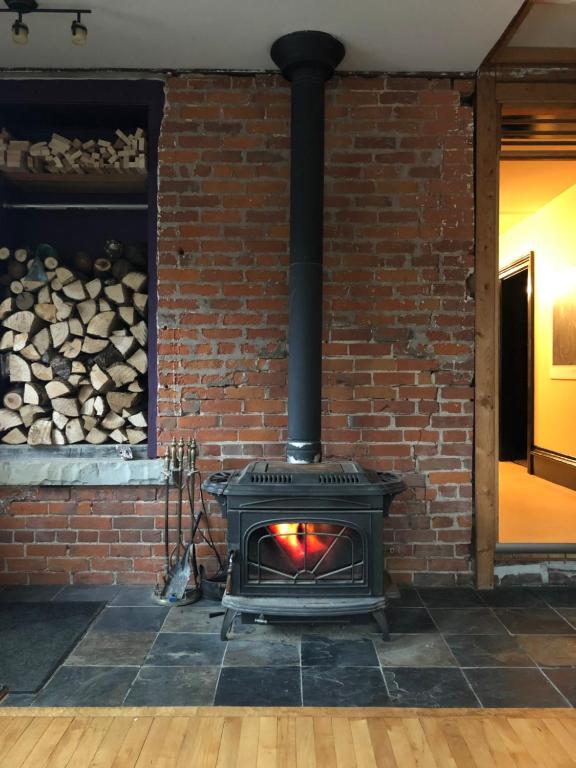 a brick fireplace with a fire in it at Lady Hamilton in Stratford